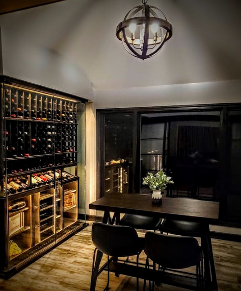 A modern, chic wine cellar with seating arrangement.