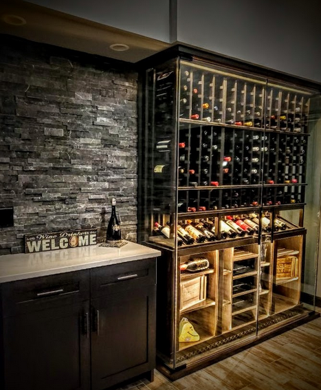 A wine cellar with glass enclosure and metal wine racking.