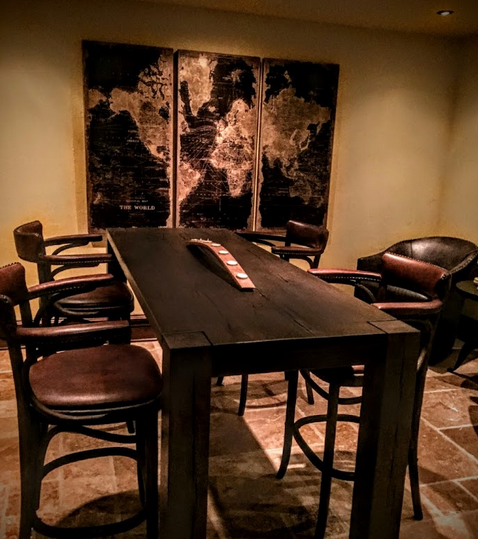 A modern wine tasting room featuring leather seats and a large painting on the wall.