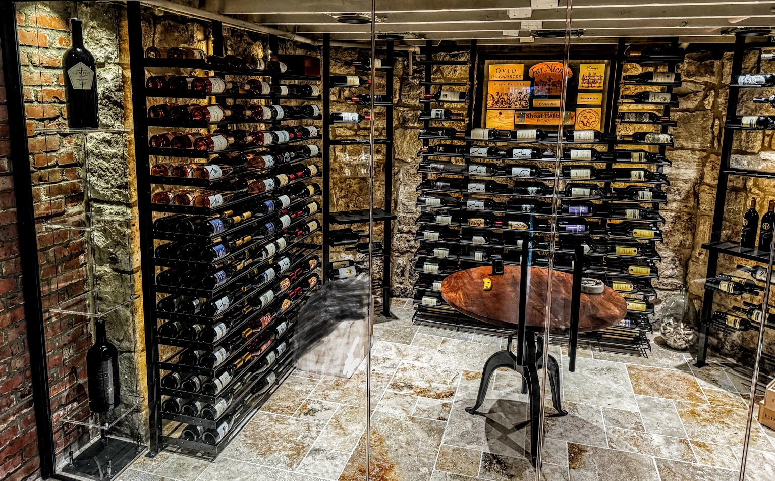 Baroque Design wine cellar with glass enclosure and brick and stone walls.