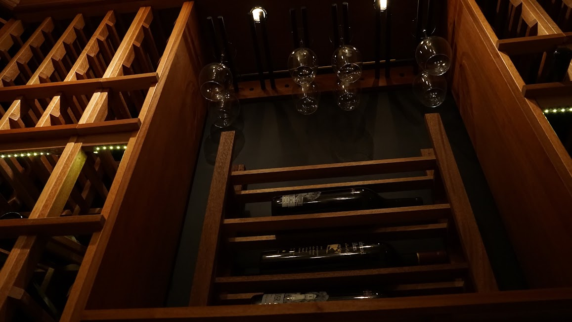 a custom wine cellar with stacked wine bottles and glasses