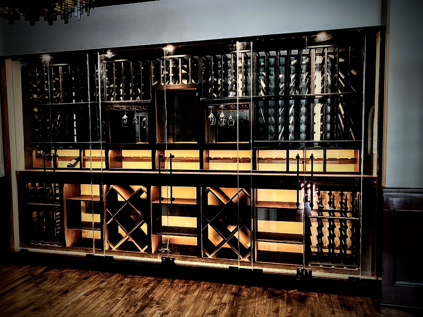 a wine cellar with a shelf full of wine bottles and wine glasses